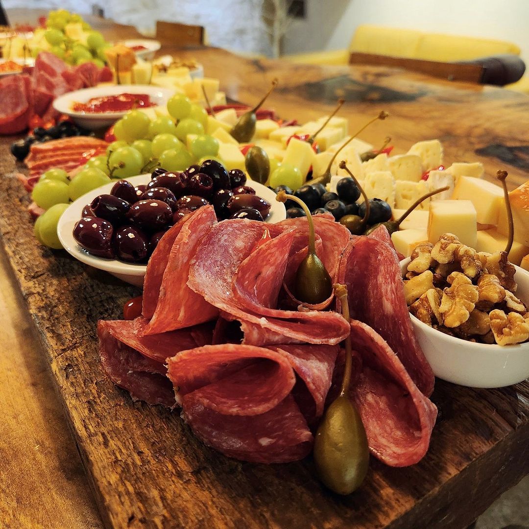 Our charcuterie: Genoa salami, olives, grapes, cheese and walnuts on a wood board